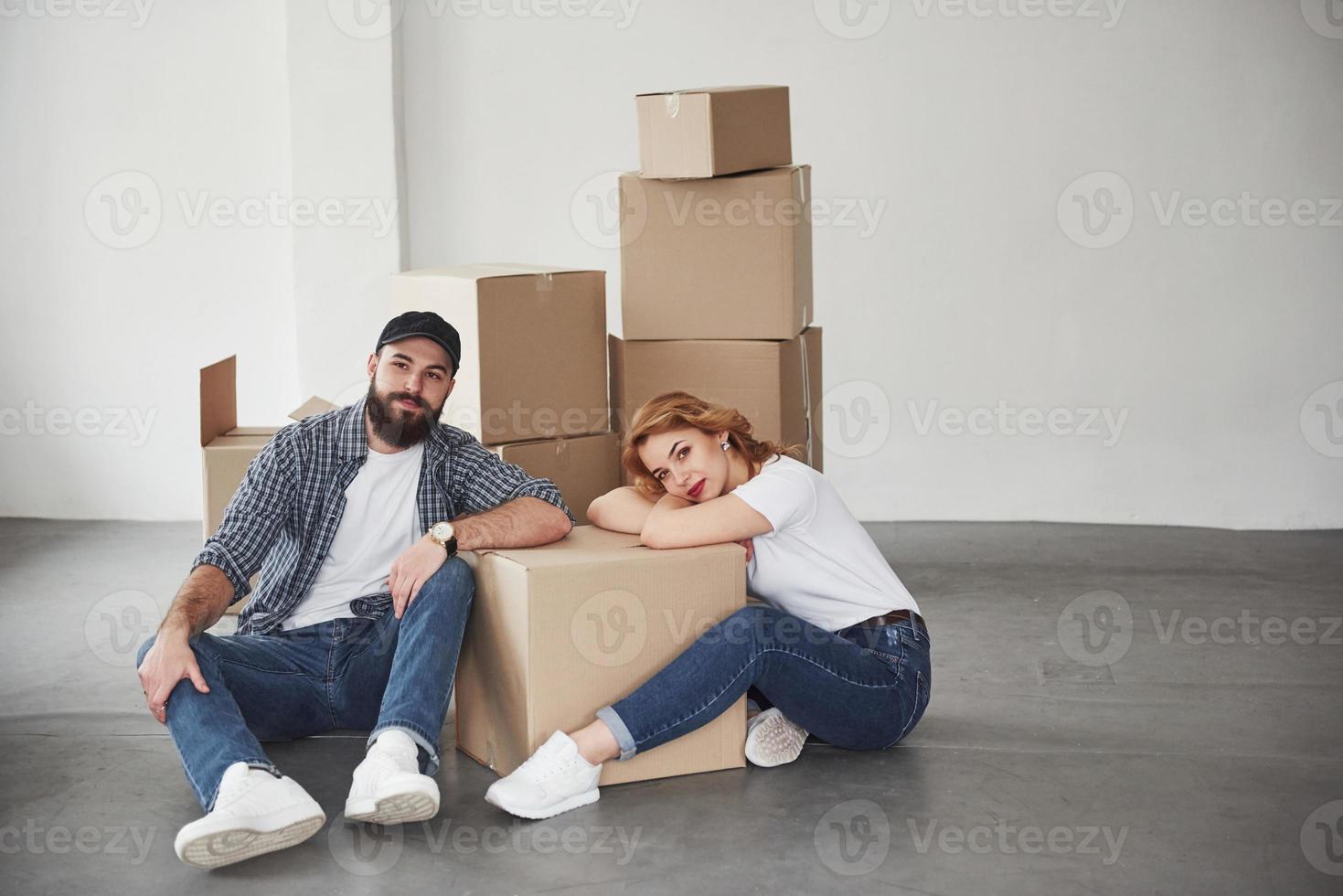 Looking straight into the camera. Happy couple together in their new house. Conception of moving photo