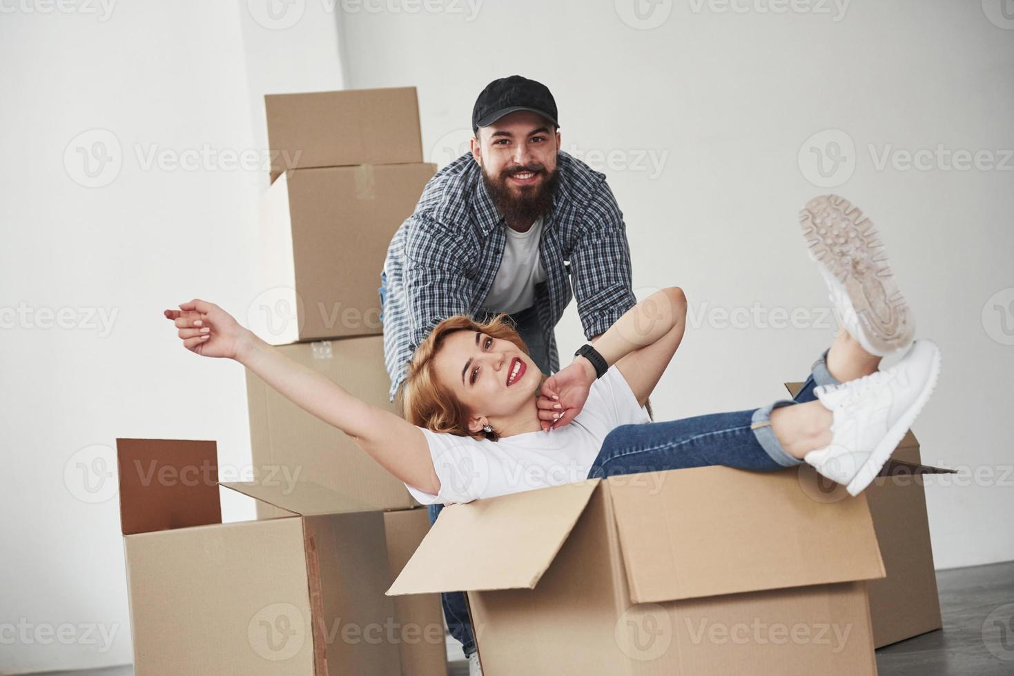 Relaxation when sitting in the empty box. Happy couple together in their new house. Conception of moving photo
