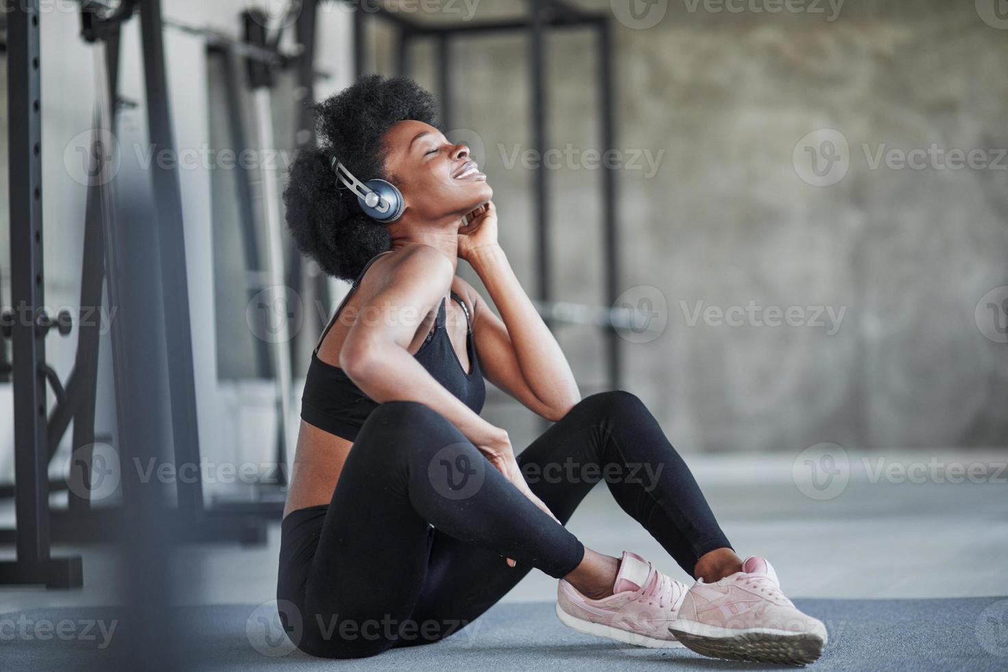 descanso después del entrenamiento. mujer afroamericana con cabello rizado  y ropa deportiva tiene un día de fitness en el gimnasio 15196285 Foto de  stock en Vecteezy