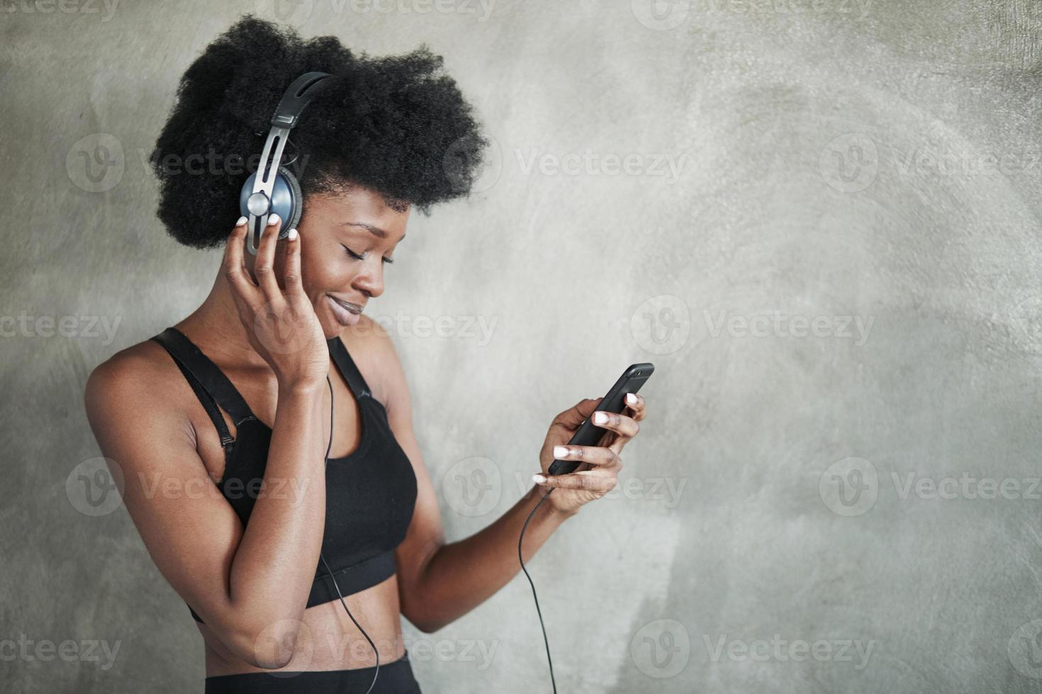 With eyes closed. Portrait of african american girl in fitness clothes having a break after workout photo