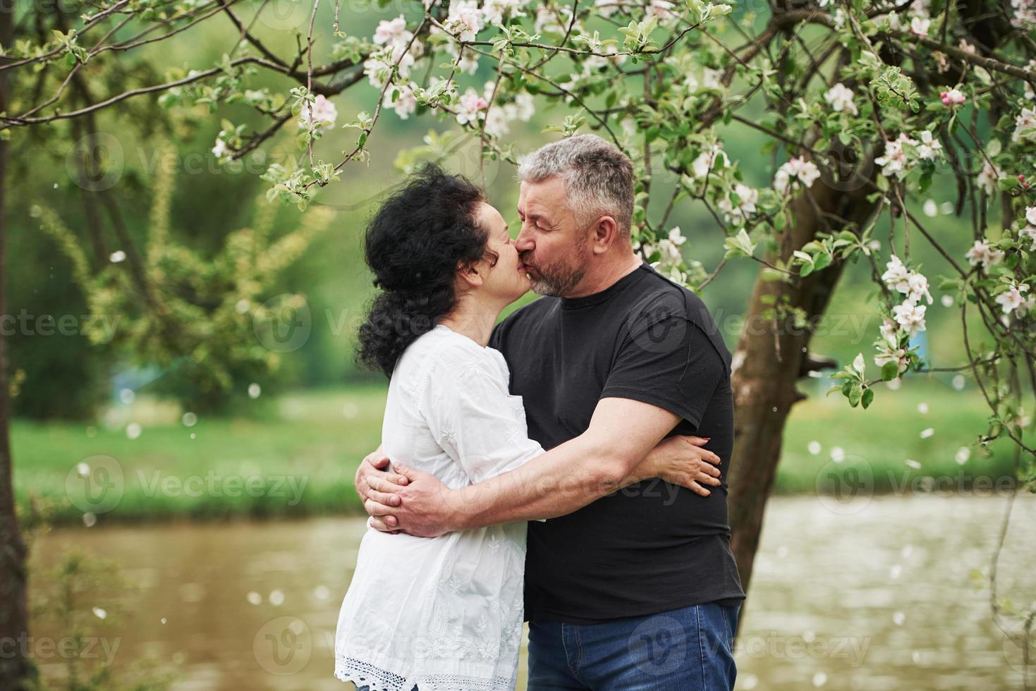 Giving a kiss. Cheerful couple enjoying nice weekend outdoors. Good spring weather photo