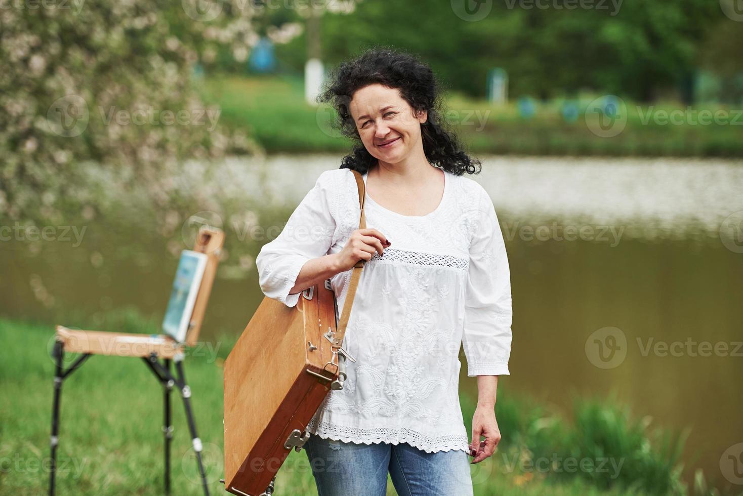 Spring weather. Mature painter with case of instruments have a walk in the beautiful park photo