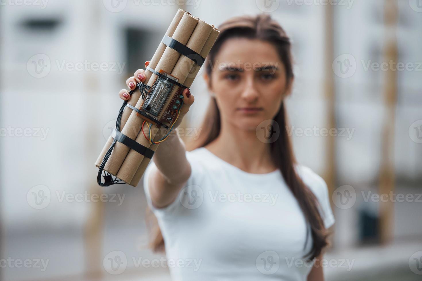 elementos digitales. mostrando bomba de tiempo. mujer joven sosteniendo un arma explosiva peligrosa en la mano foto