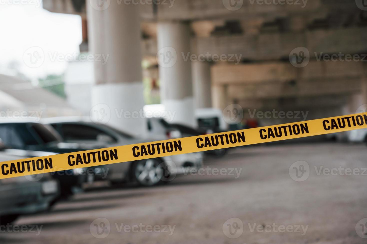 Crime scene protected by tape. Car parking lot at daytime outdoors photo