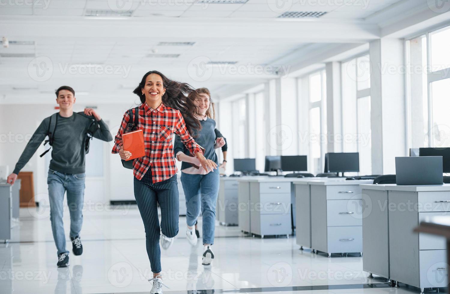 Hurry up, our day is done. Group of young people walking in the office at their break time photo