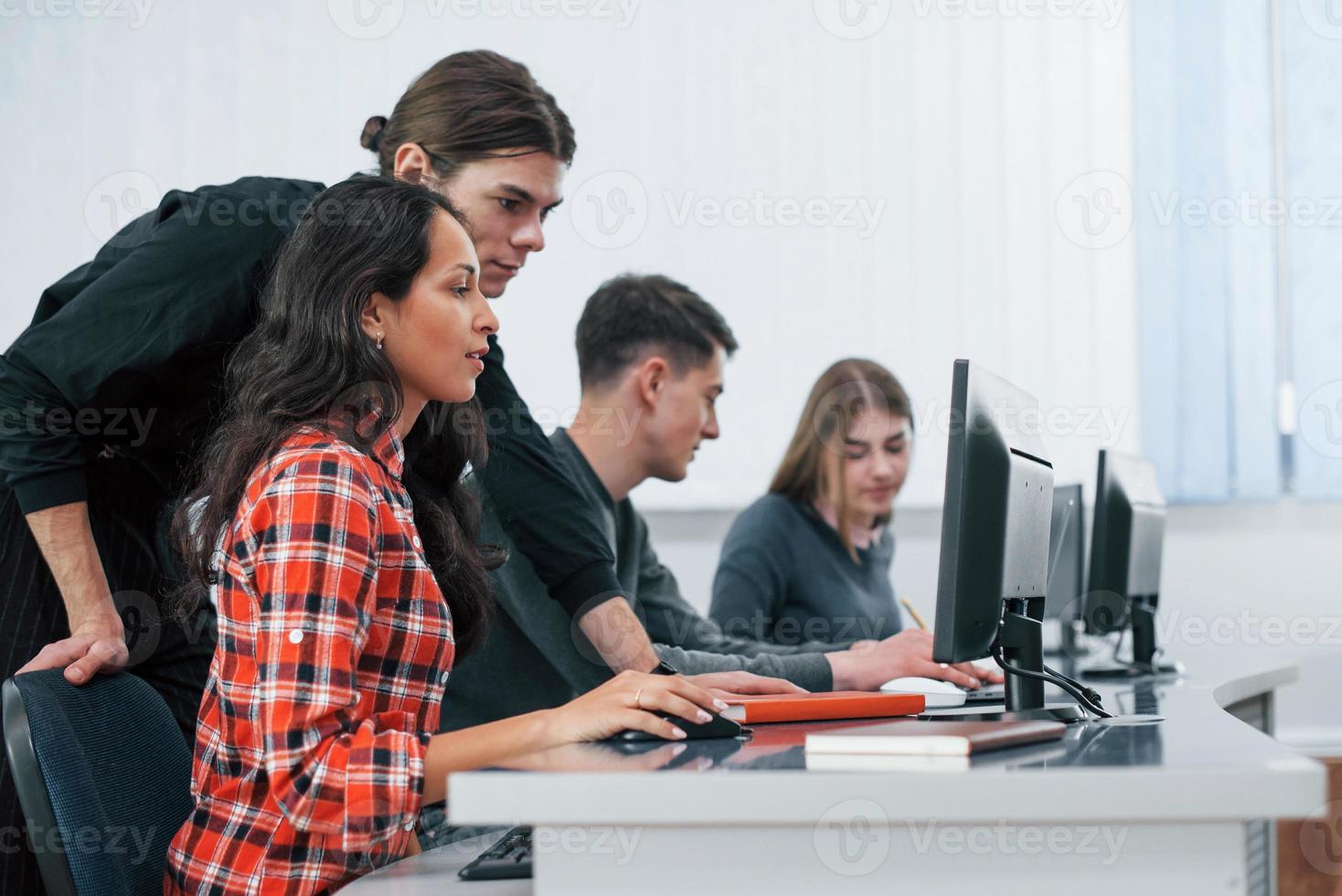 Am I doing it right. Group of young people in casual clothes working in the modern office photo