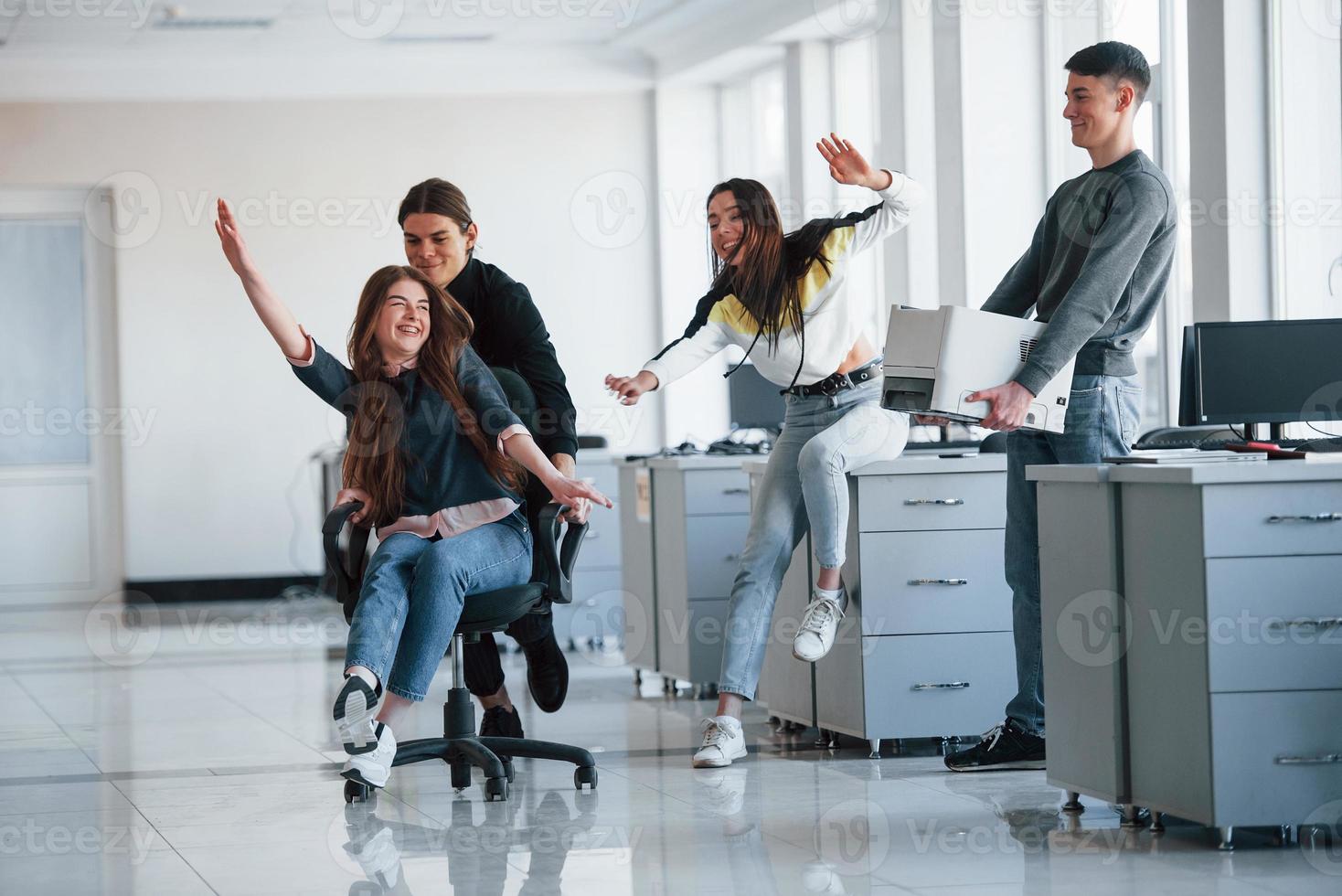 Feeling freedom. Having fun in the office. Young people have a break and driving by using a seat photo