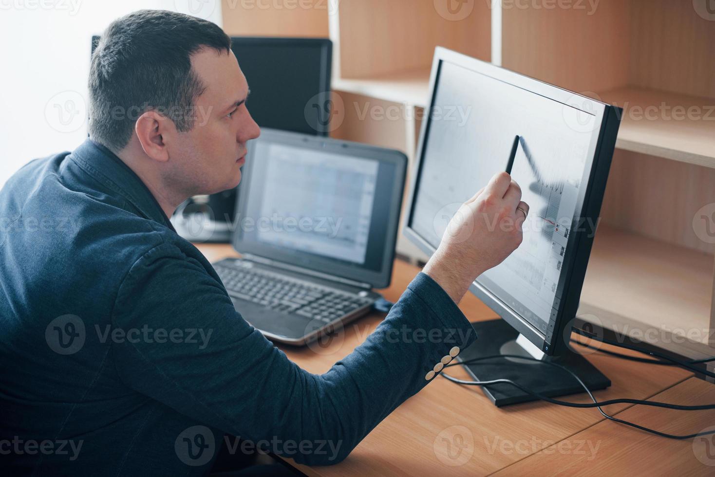 I see how man had worried at this moment. Polygraph examiner works in the office with his lie detector's equipment photo