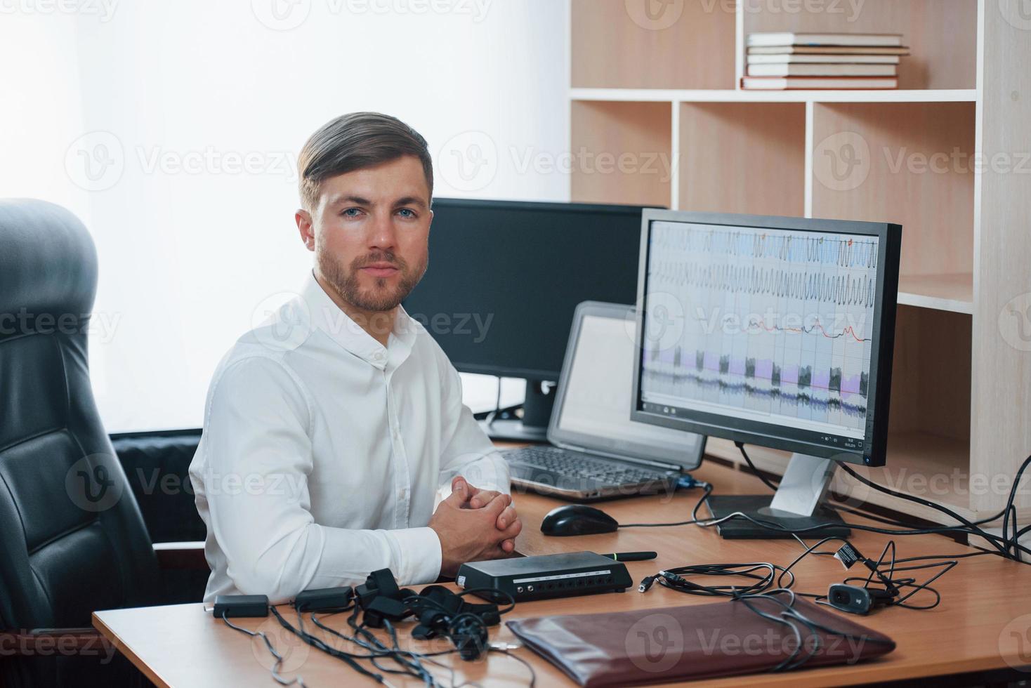 In the workplace. Polygraph examiner works with his lie detector's equipment photo