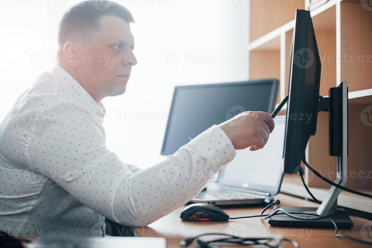 Natural daylight comes through the window. Polygraph examiner works in the office with his lie detector's equipment photo