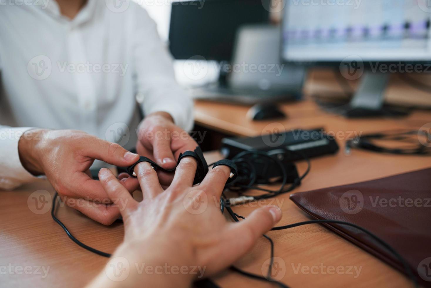Giving the hand. Preparation for the polygraph test. Conception of the lie detector photo