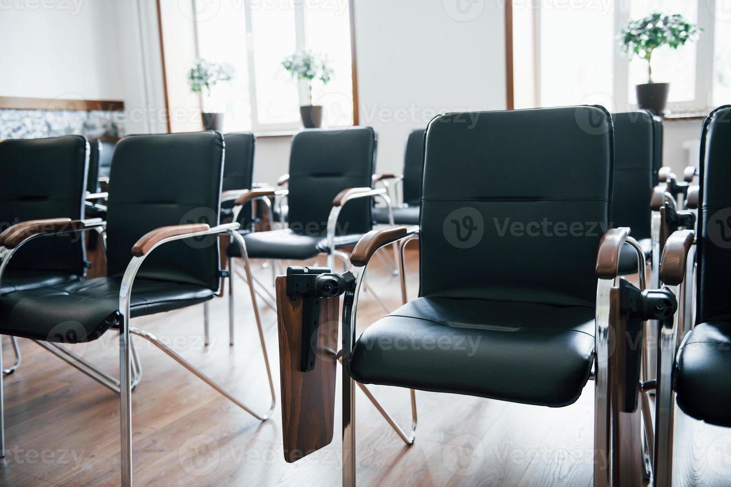 aula de negocios durante el día con muchas sillas negras. listo para los estudiantes foto
