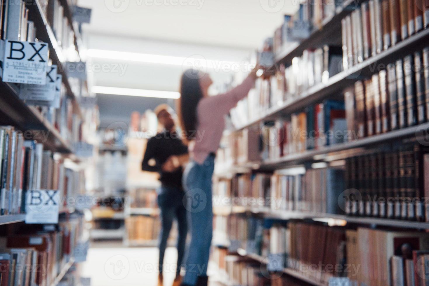 Blurred photo. Multiracial students in the library searching for the information together photo