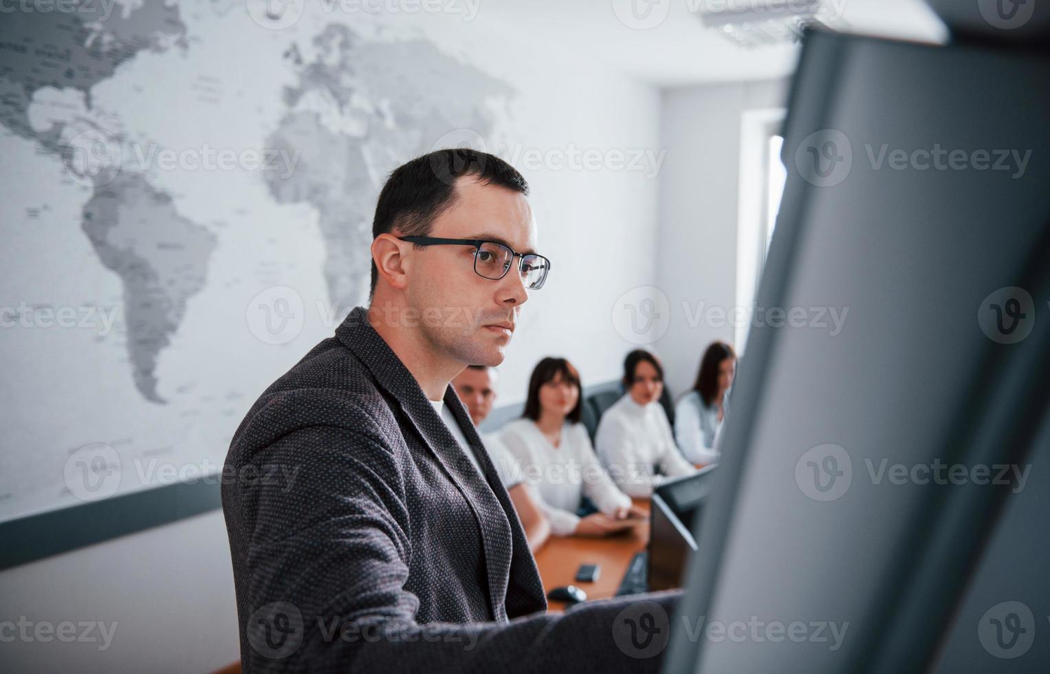 Take a look at this graph. Group of people at business conference in modern classroom at daytime photo