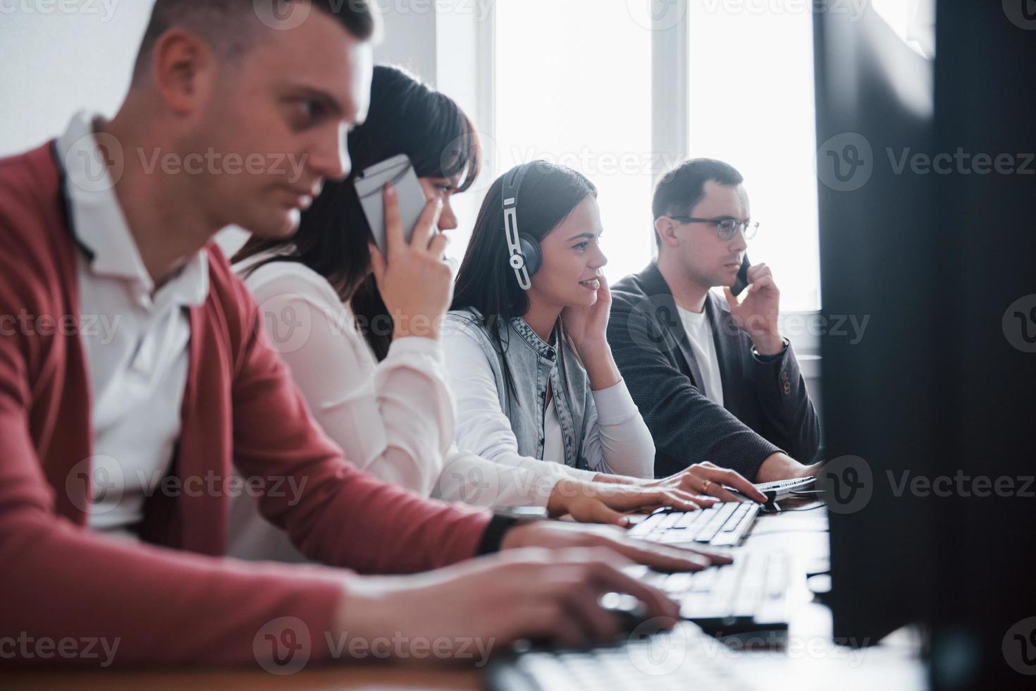 Corporate business. Young people working in the call center. New deals is coming photo
