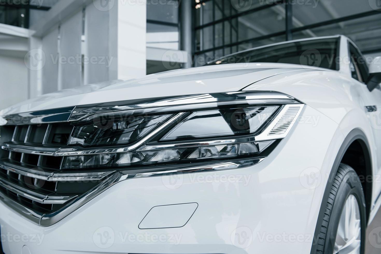 Beautiful design. Particle view of modern luxury white car parked indoors at daytime photo