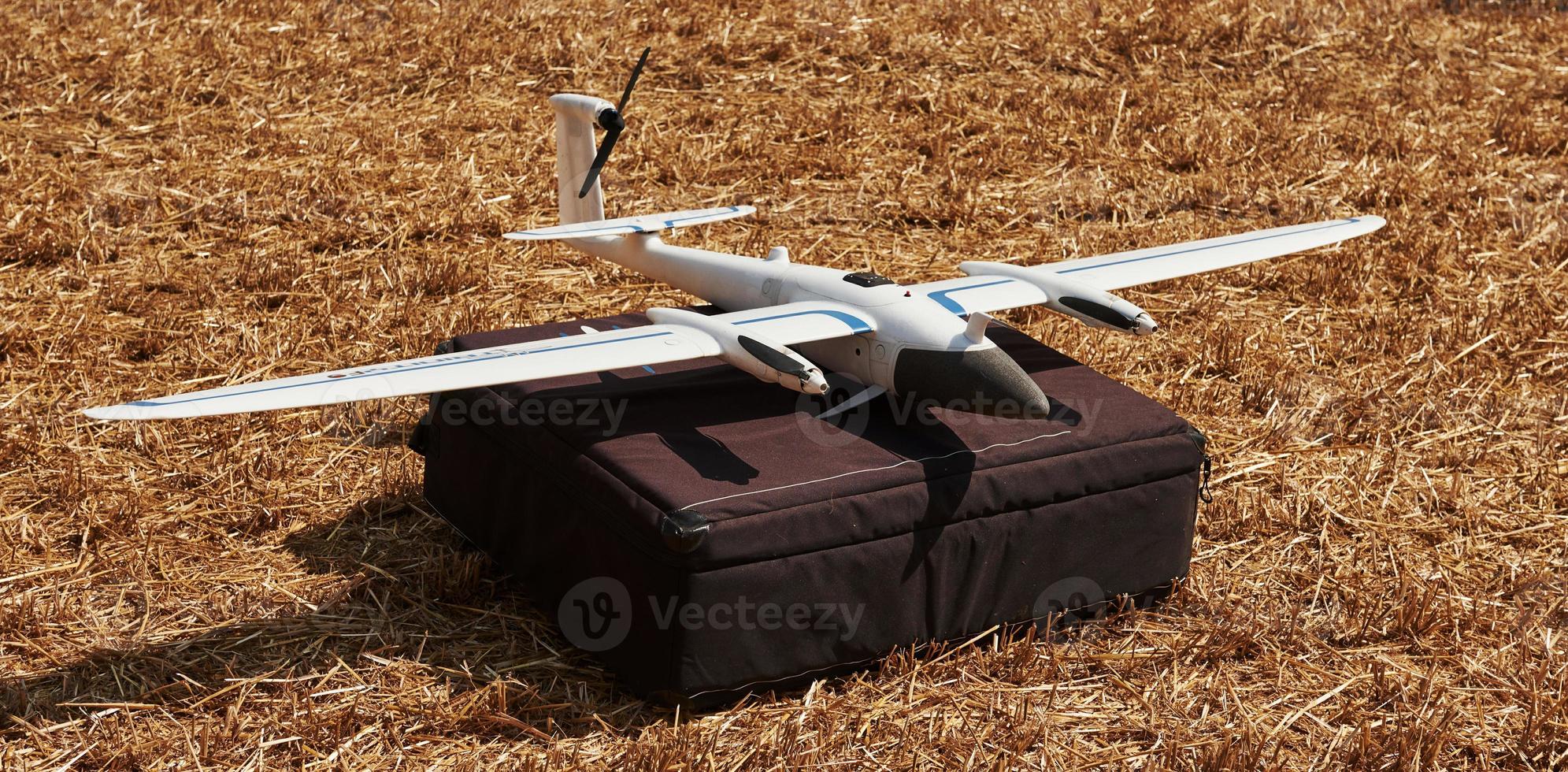 Modern small remote controlled white colored plane on black bag. Ready to fly photo