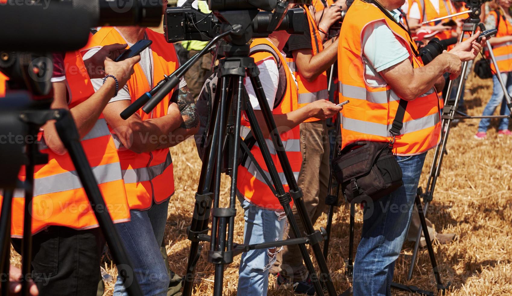 grupo de personas en uniforme amarillo y con cámaras al aire libre en el campo foto