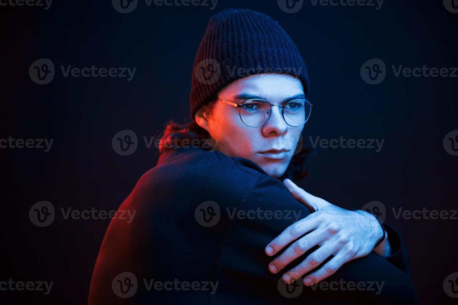 Thinking about some problems. Studio shot in dark studio with neon light. Portrait of serious man photo