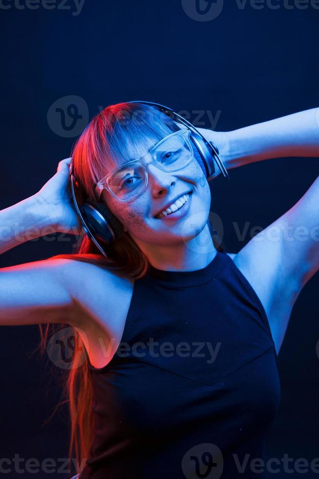 emoción positiva. foto de estudio en estudio oscuro con luz de neón. retrato de niña