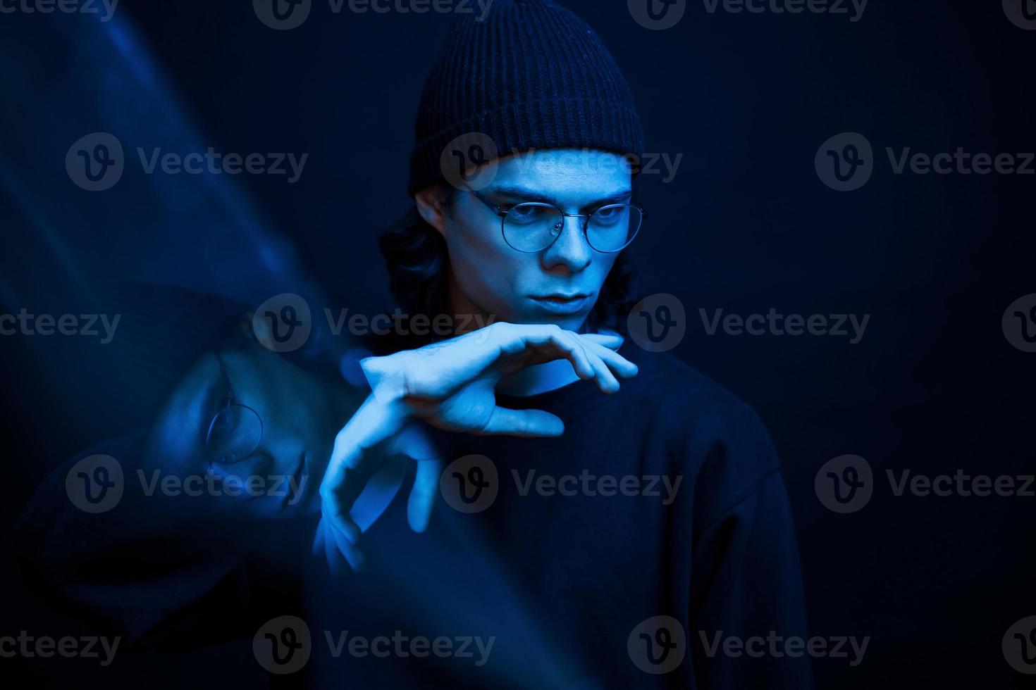 Cinematic effect. Studio shot in dark studio with neon light. Portrait of serious man photo