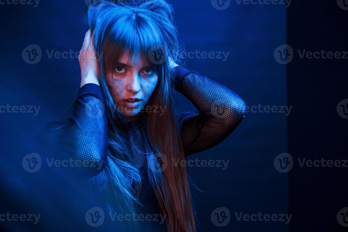 Passion and sensuality. Studio shot in dark studio with neon light. Portrait of young girl photo