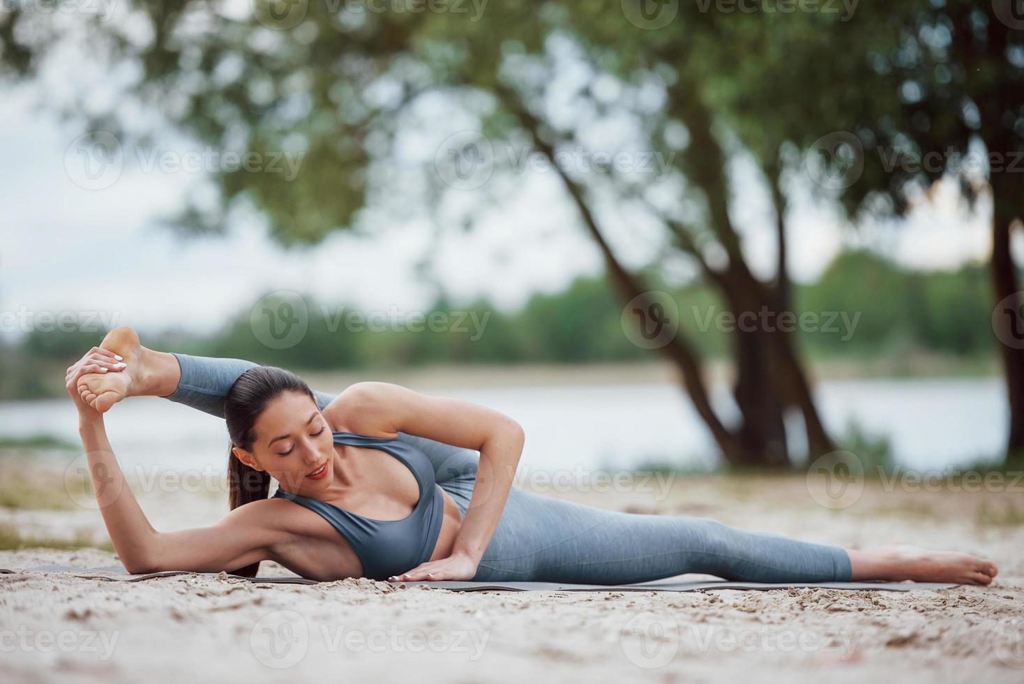 Professional sports. Brunette with nice body shape have fitness day on a beach photo