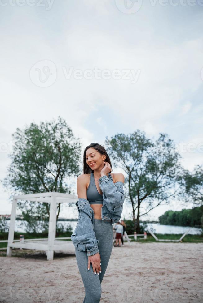 Positive woman in sportive clothes enjoying nature on the beach photo