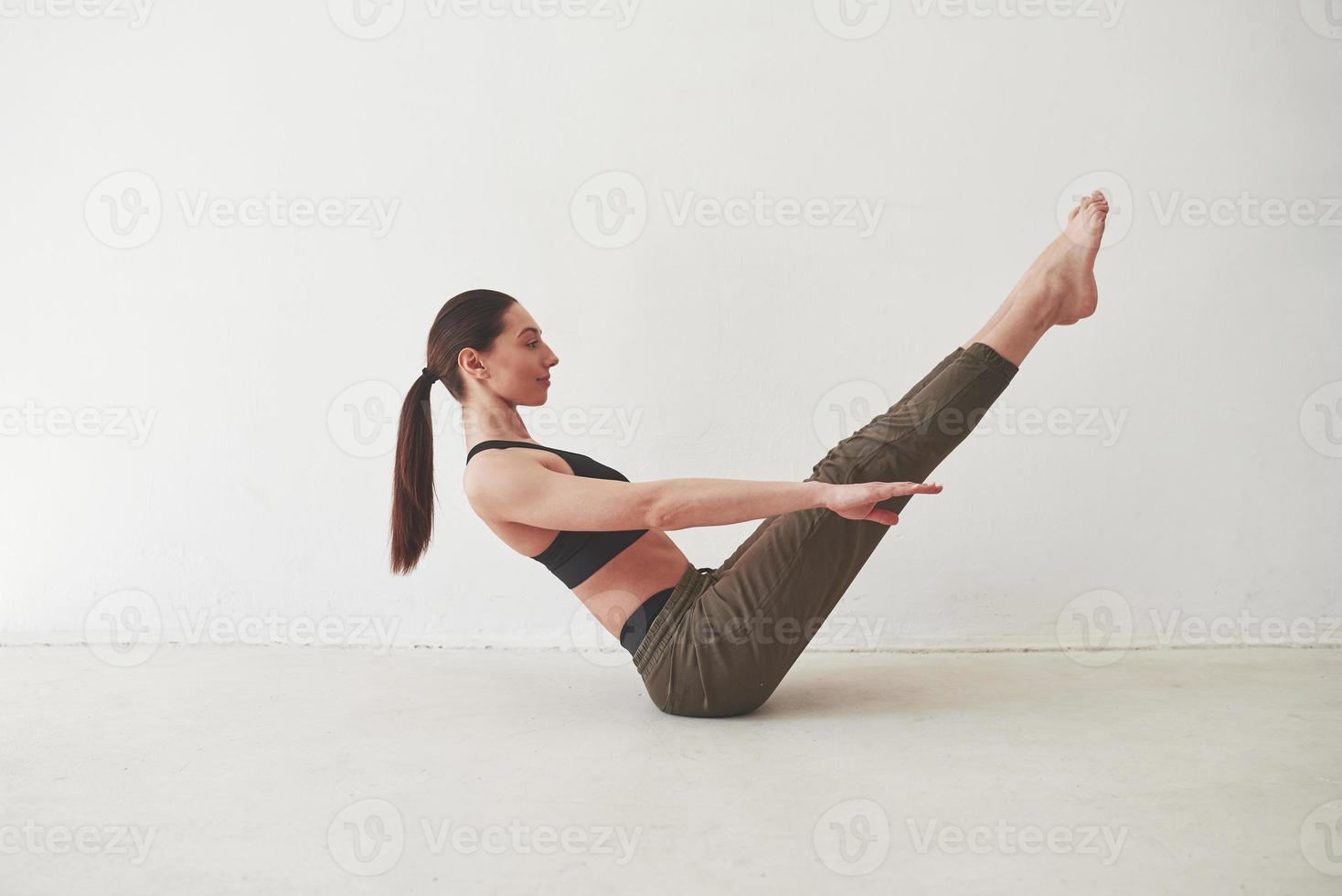 Confident girl. Caucasian pretty woman stands against white background in the empty room photo