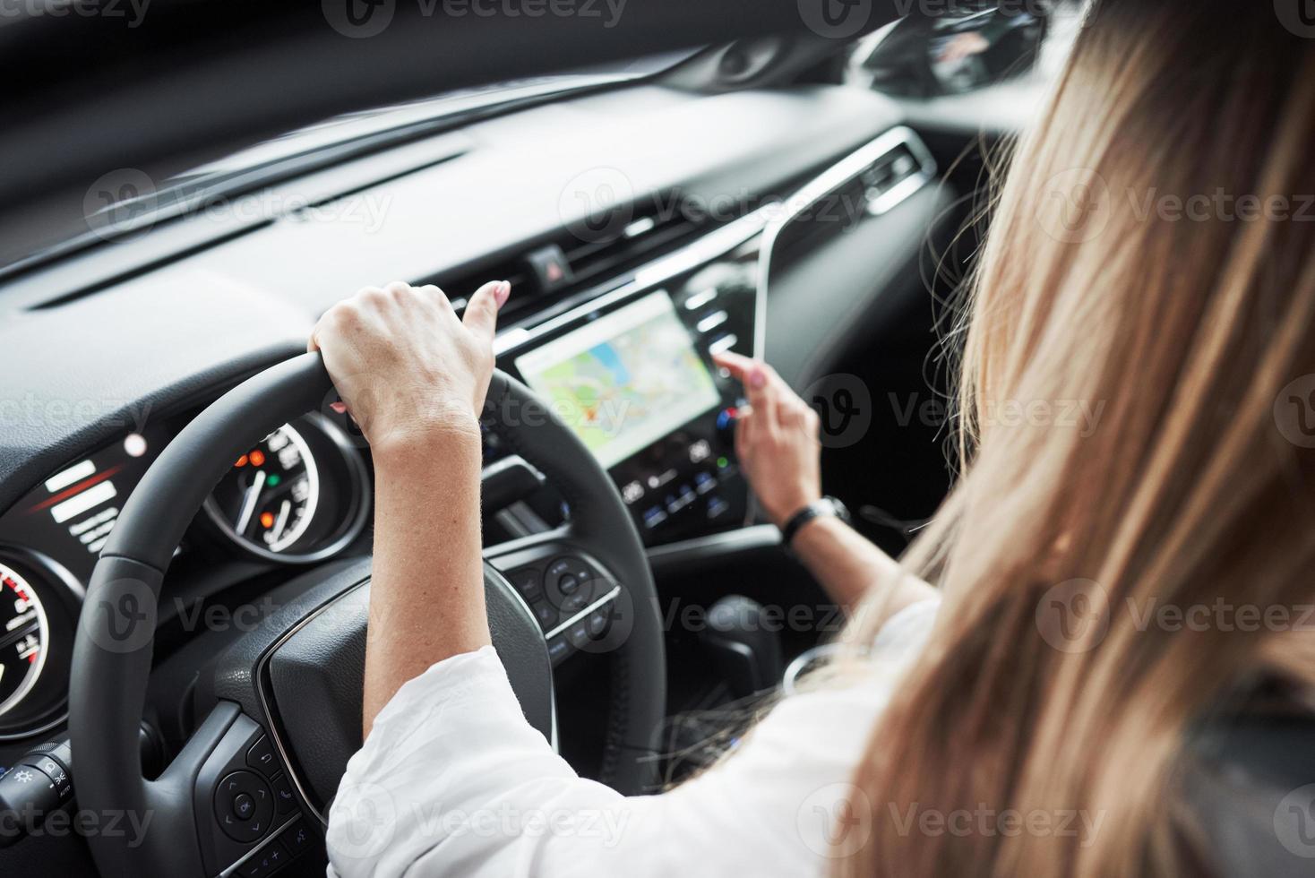Using map on display. Close up view of woman's hands in the beautiful modern black colored car photo