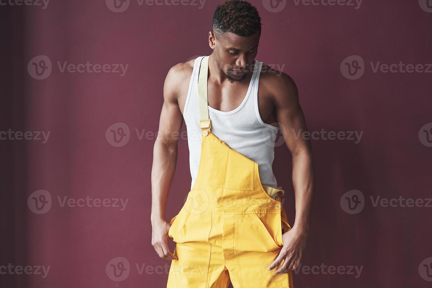 hombre moderno de moda. joven trabajador afroamericano en el uniforme amarillo tiene algún trabajo foto