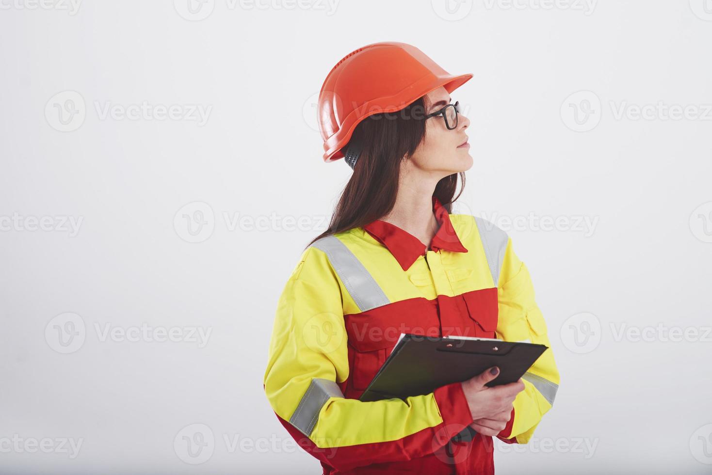 Object overview. Brunette woman in orange and yellow uniform stands against white background in the studio photo