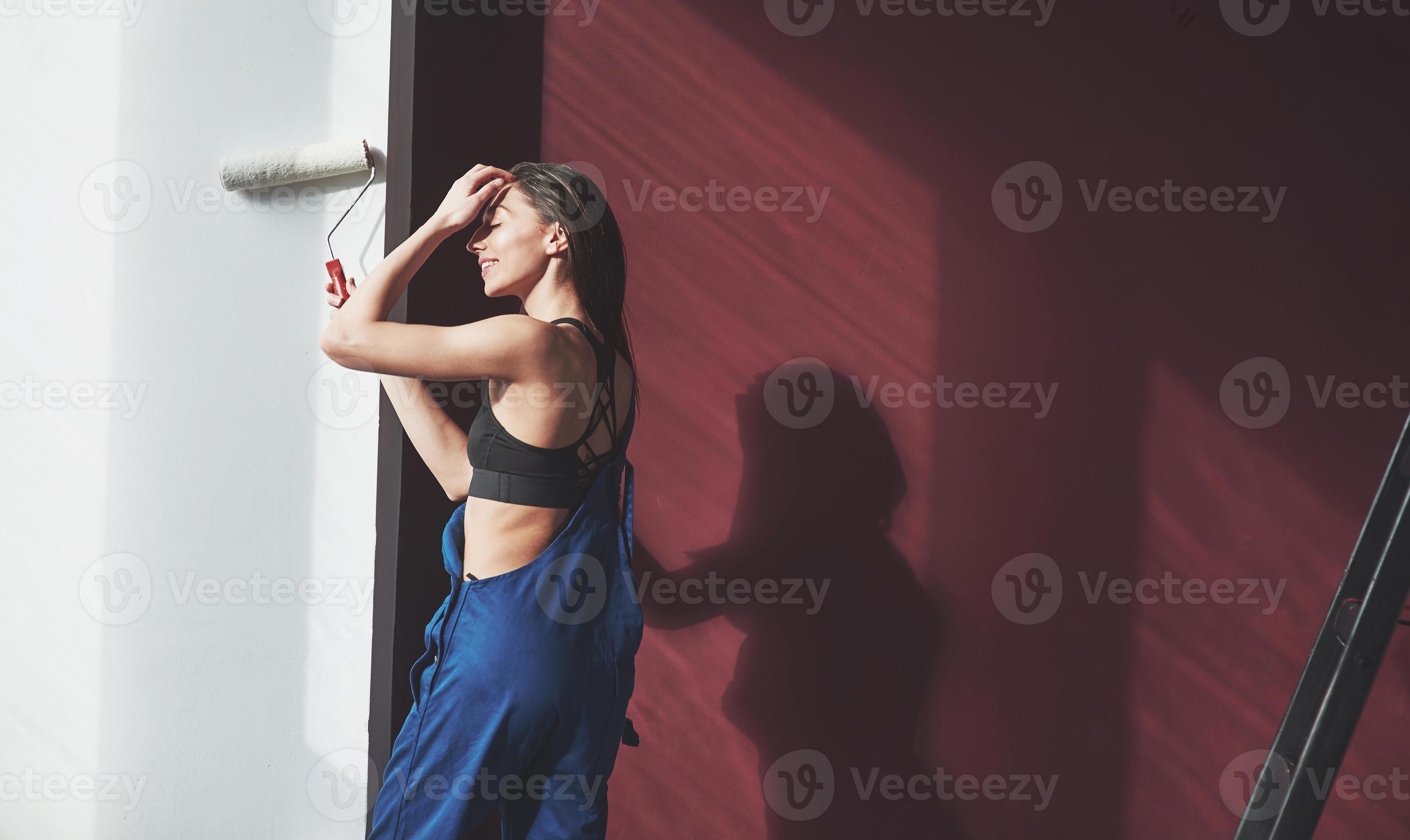 Enjoying warm sunlight that comes through the window. Young housewife