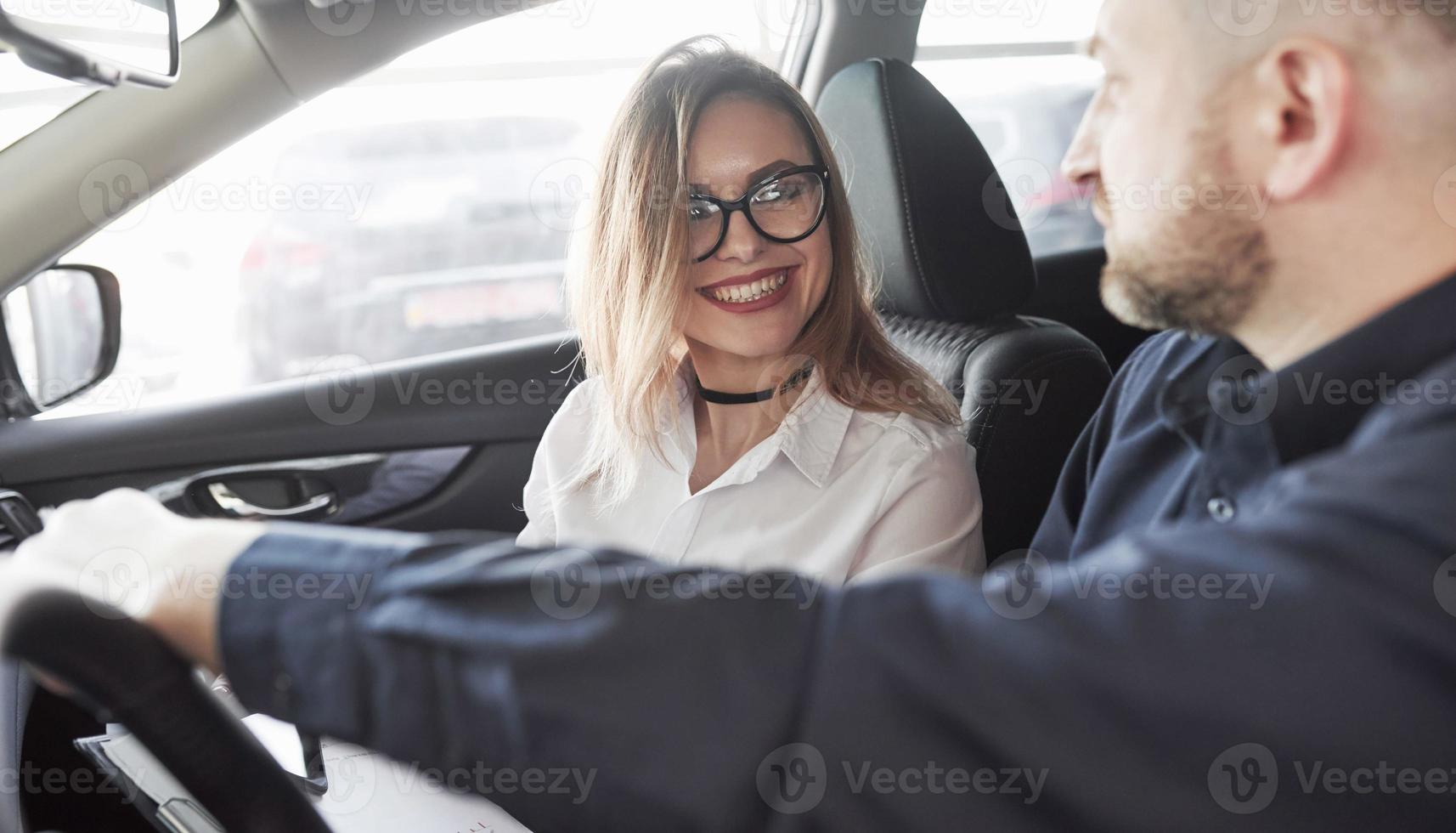 siempre feliz de ayudarte. subdirector dando consejos al cliente en el salón del automóvil foto