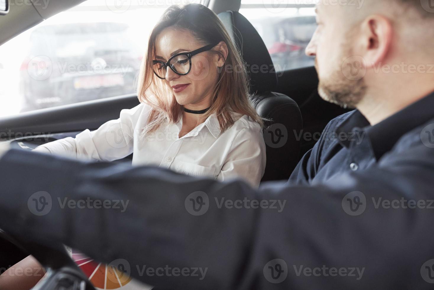 Caucasian ethnicity. Assistant manager giving advices and help to the customer in automobile salon photo