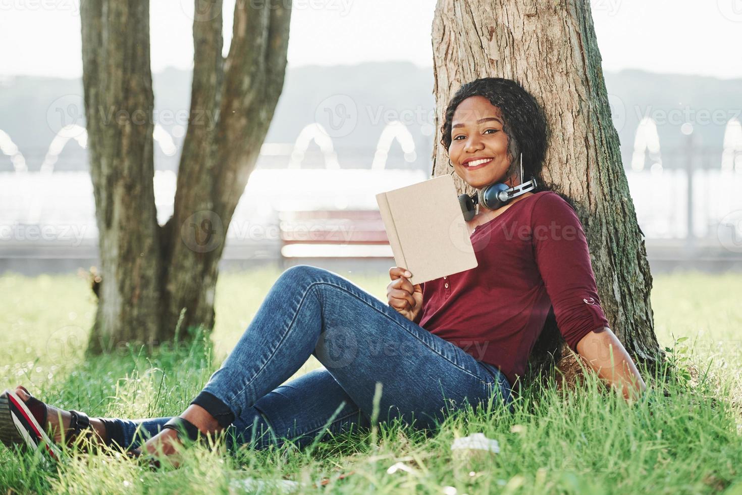 Hello there. Cheerful african american woman in the park at summertime photo