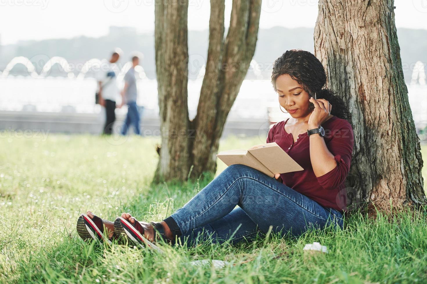 Such a beautiful place. Cheerful african american woman in the park at summertime photo