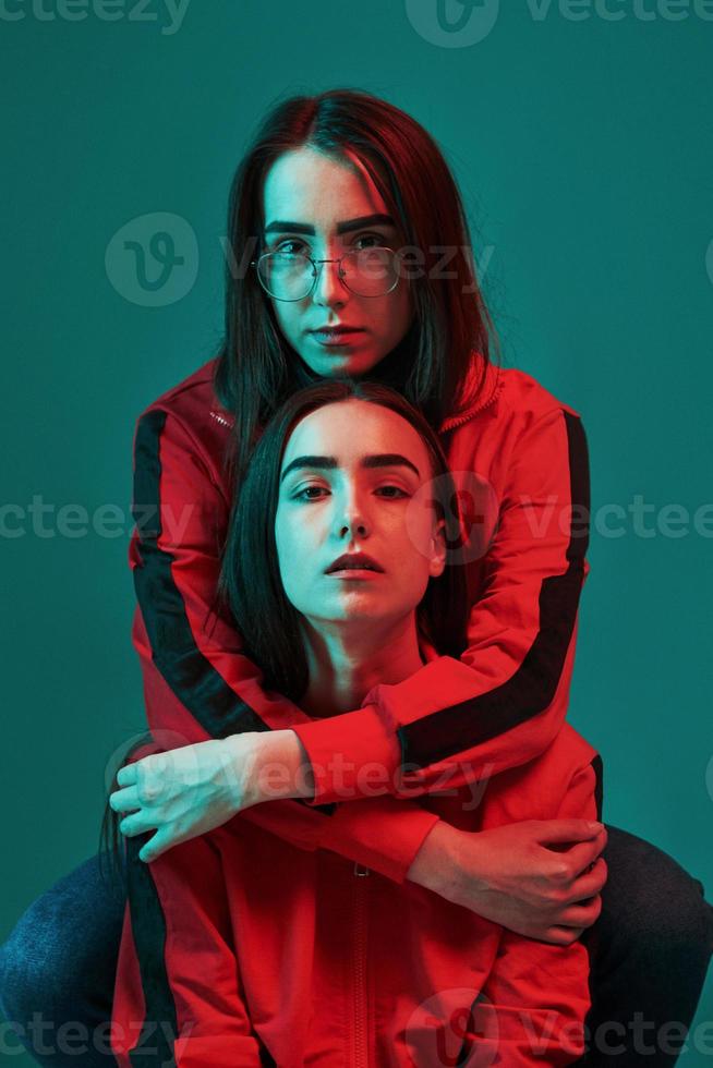 Family is important. Studio shot indoors with neon light. Photo of two beautiful twins