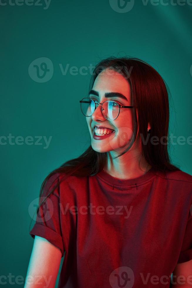 Have good day. Studio shot indoors with neon light. Portrait of beautiful young girl photo