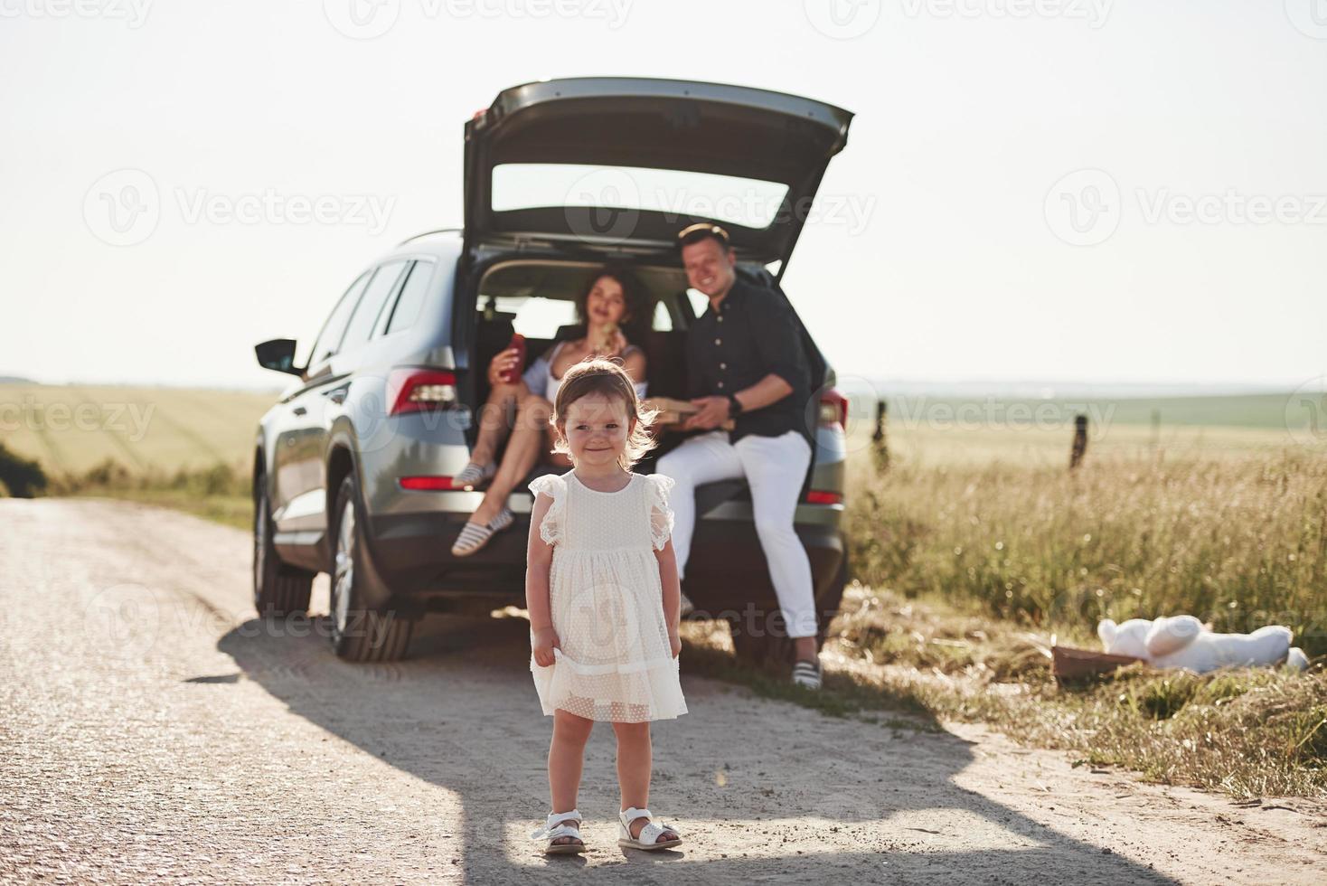 Shy kid. Beautiful people is in the modern car at their weekends photo