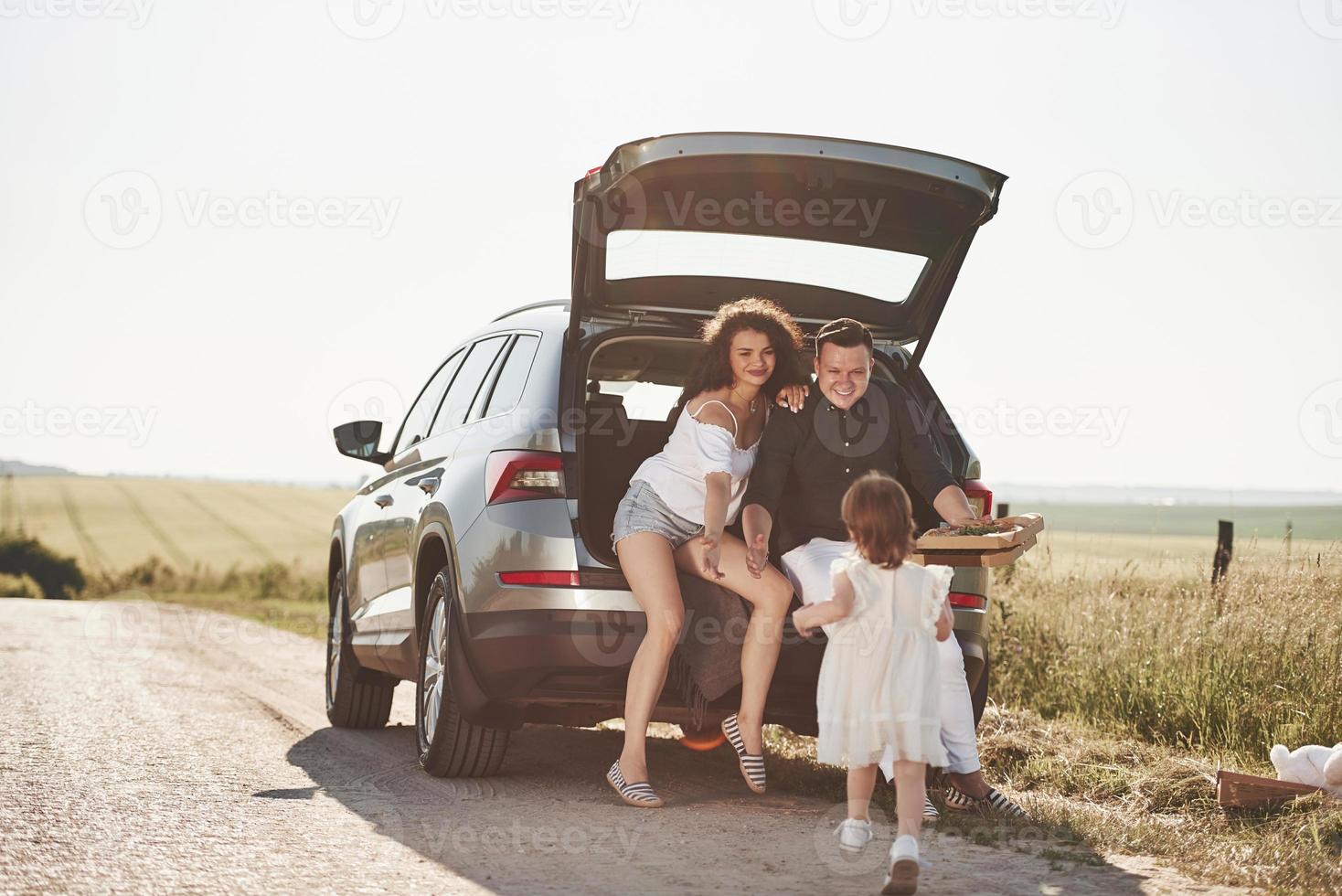 corriendo hacia los padres. la gente hermosa está en el automóvil moderno los fines de semana foto