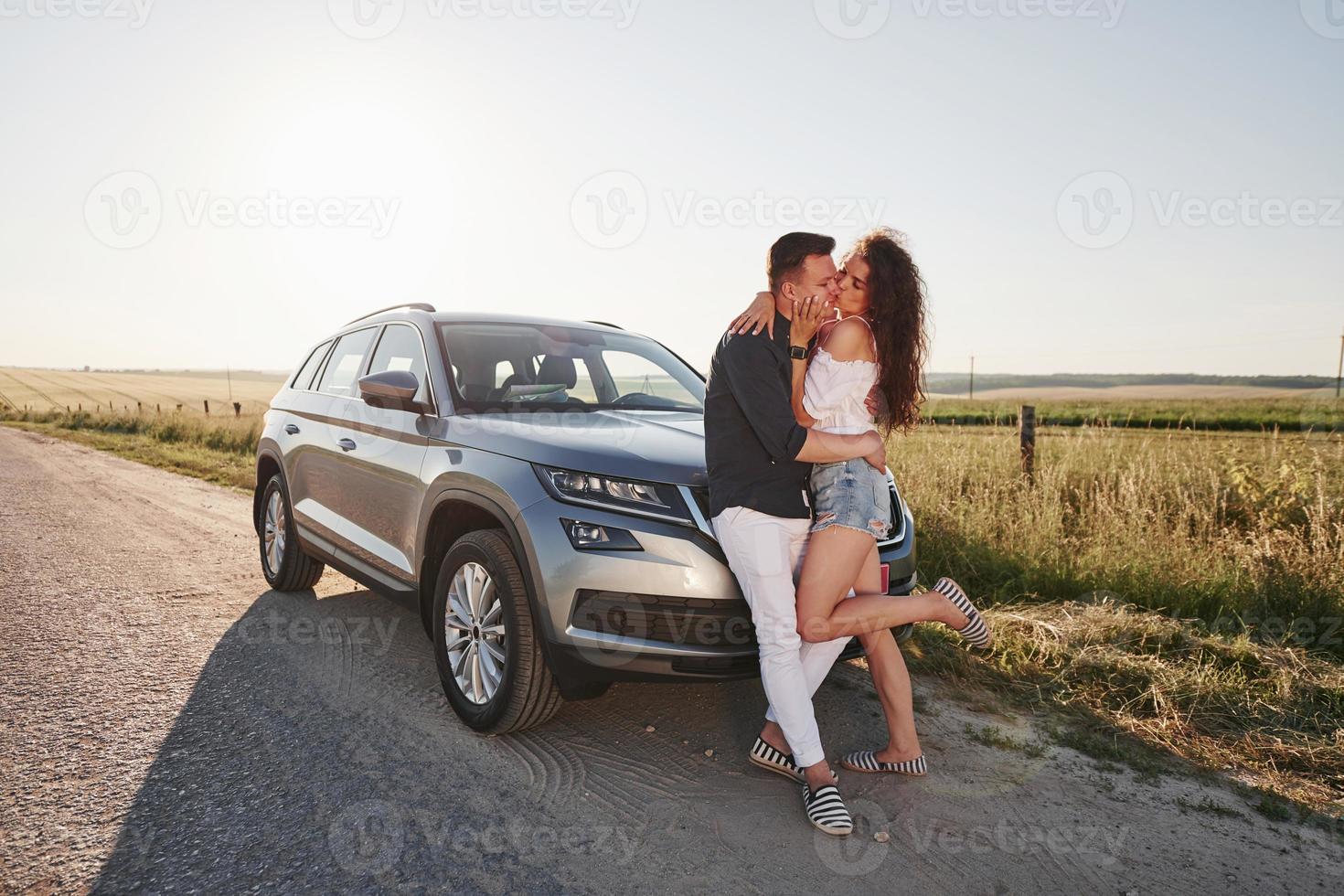 Lovely couple near their new modern car at weekend time photo