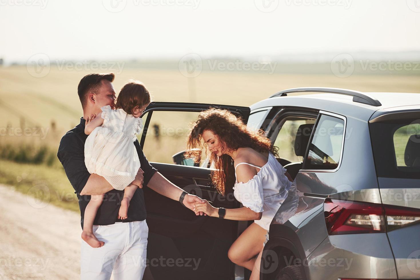 el hombre ayuda a salir. la gente hermosa está en el auto moderno los fines de semana foto