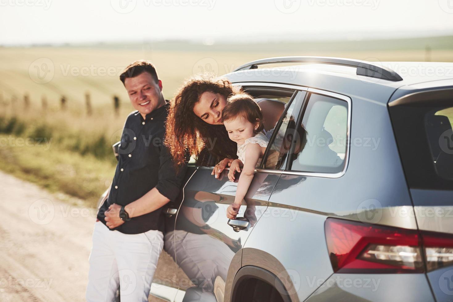 tratando de abrir la puerta. la gente hermosa está en el auto moderno los fines de semana foto