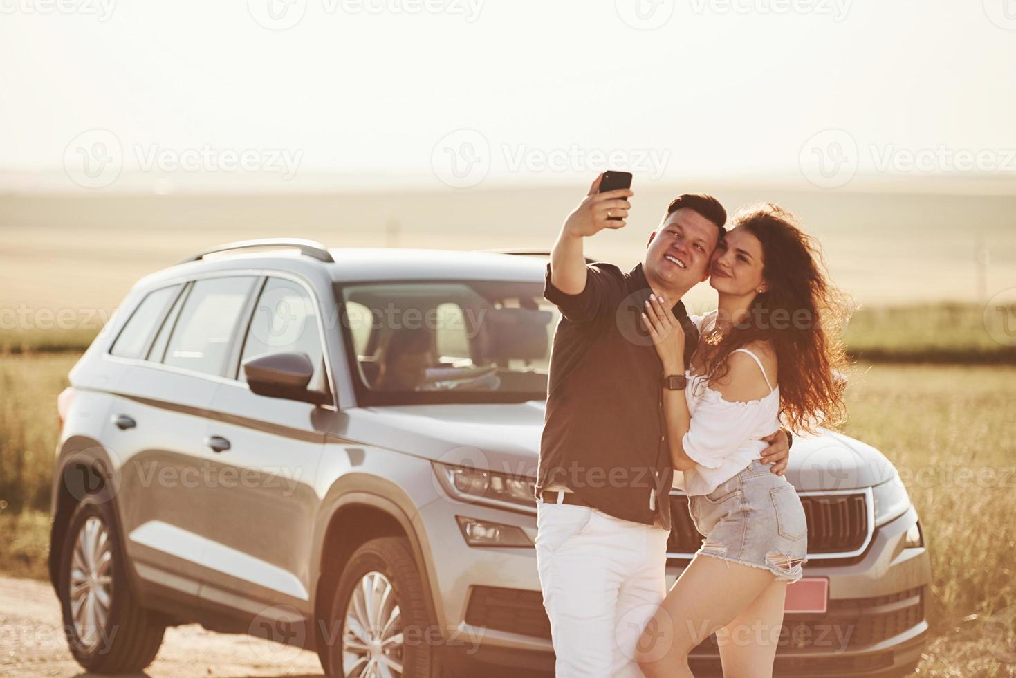 One more photo. Lovely couple near their new modern car at weekend time photo