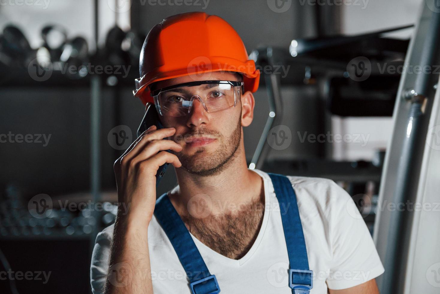 conversación importante. retrato de ingeniero en fábrica metalúrgica en casco protector y anteojos foto