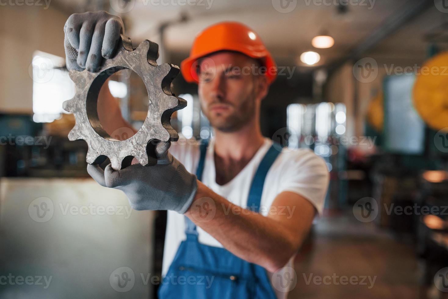 parte de la máquina. hombre en uniforme trabaja en la producción. tecnología industrial moderna foto