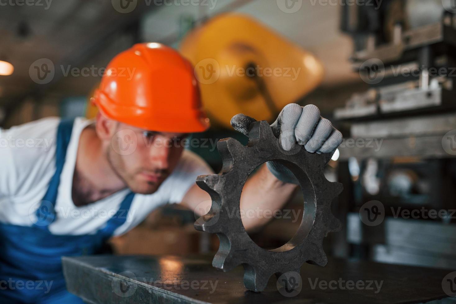 Searching for defects. Man in uniform works on the production. Industrial modern technology photo