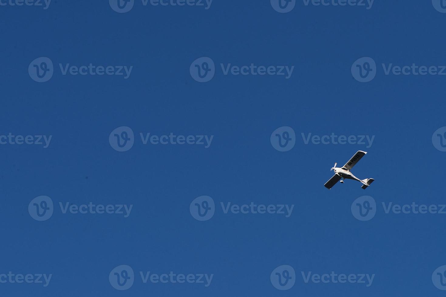 Biplane flying high in the blue sky at sunny day. Speed and energy photo