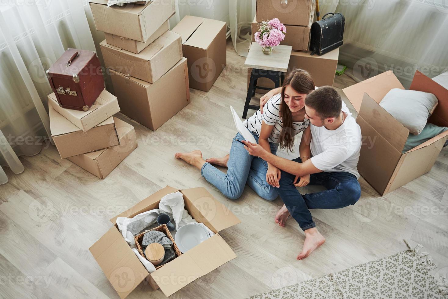 View from the top. Cheerful young couple in their new apartment. Conception of moving photo